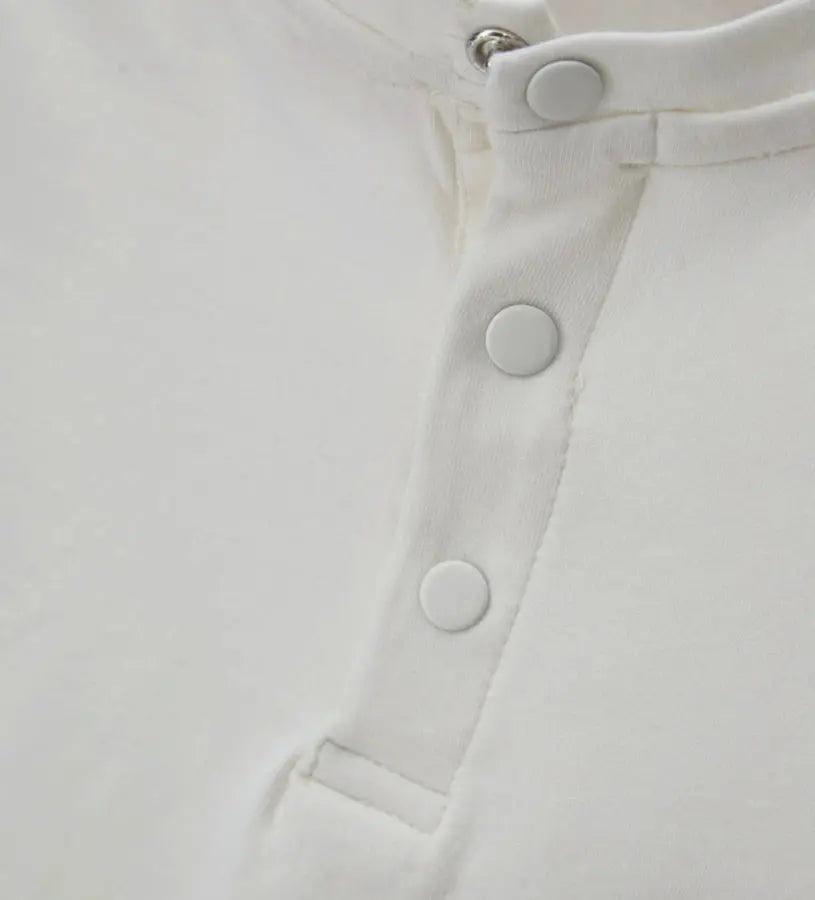 Κοντινό πλάνο στα κουμπιά-σούστες ανάμεσα στα πόδια για εύκολη αλλαγή πάνας.