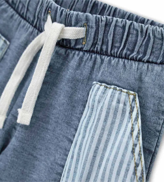 Κοντινό πλάνο στο ρυθμιζόμενο κορδόνι και την ύφανση denim της βρεφικής βερμούδας.