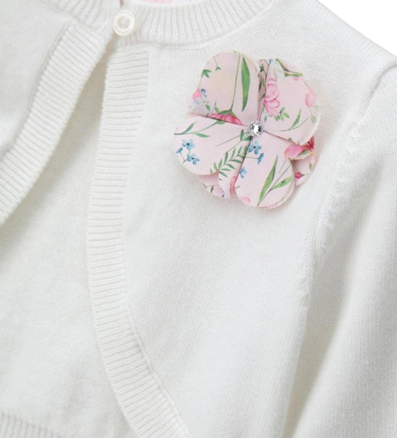 Λεπτομέρεια από το λουλούδι κρεπ και το άνοιγμα με το κουμπί στην παιδική ζακέτα.