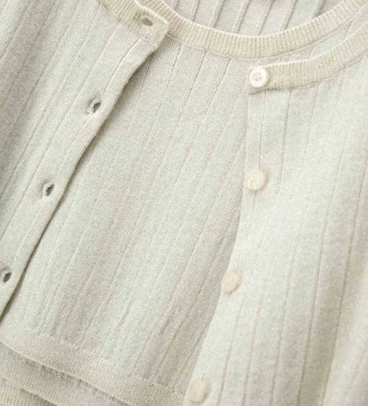 Λεπτομέρεια από το πλεκτό τοπ και τη ριμπ ύφανση του κοριτσίστικου σετ twinset.