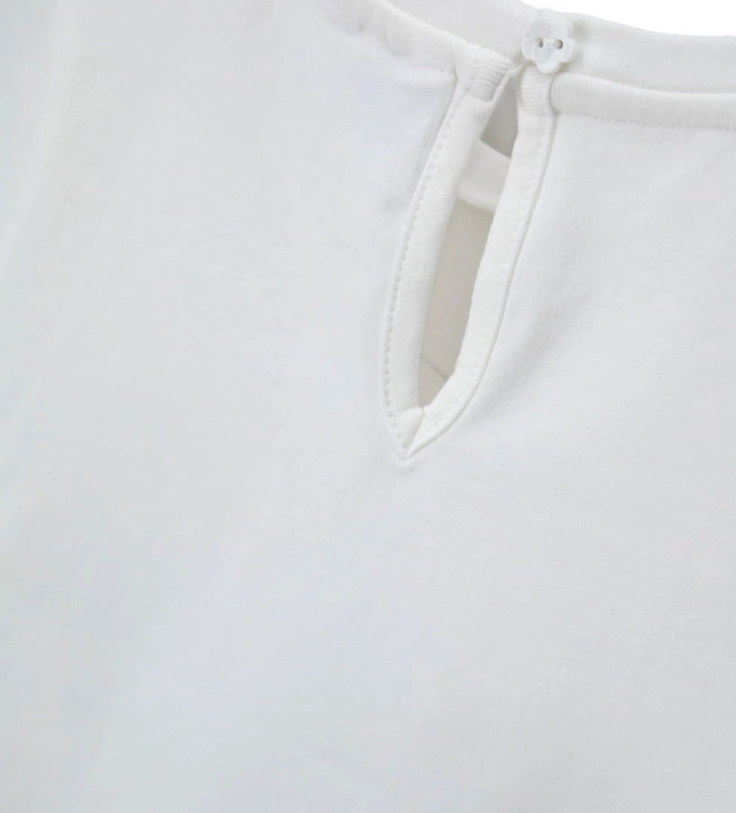 Λεπτομέρεια από το άνοιγμα keyhole στην πλάτη και την ελαστική ραφή στο λευκό T-shirt.